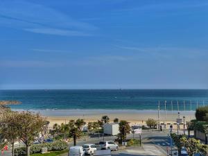 - un parking à côté d'une plage avec des voitures dans l'établissement 2 Pièces Terrasse Vue mer, à Dinard