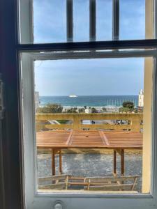 une fenêtre avec un banc donnant sur l'océan dans l'établissement 2 Pièces Terrasse Vue mer, à Dinard 1 autre photo