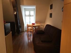 a living room with a couch and a table at Studio face au Thermes in Le Mont-Dore