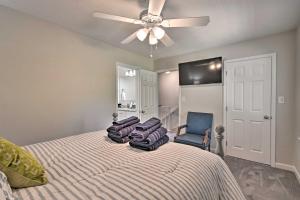 a bedroom with a bed with a ceiling fan and a chair at Downtown Southern Pines Townhome with Deck! in Southern Pines
