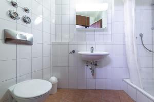 Baño blanco con aseo y lavamanos en Ferienwohnpark Immenstaad am Bodensee Ein-Zimmer-Apartment 55 11 en Immenstaad am Bodensee