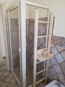 una doccia con porta in vetro in bagno di Etna Casa del Sole a Nicolosi