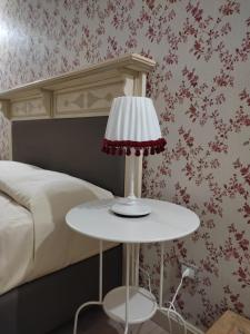 a white table with a lamp next to a bed at Etna Casa del Sole in Nicolosi