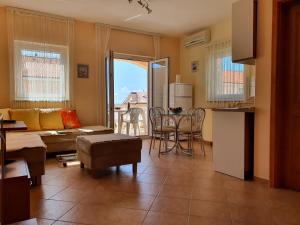 - un salon avec un canapé et une table dans l'établissement Apartments CORAL Novalja, à Novalja