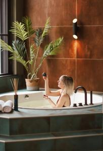 a woman is sitting in a bath tub at Oldschool Hotel in Winterswijk