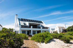 une maison avec des panneaux solaires sur la plage dans l'établissement Gonana Guesthouse, à Paternoster