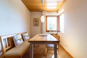 - une salle à manger avec une table et un banc dans l'établissement Ferienwohnpark Immenstaad am Bodensee Zwei-Zimmer-Apartment 55 23, à Immenstaad am Bodensee