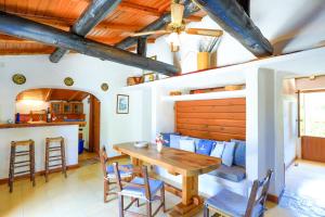 ein Esszimmer mit einem Holztisch und Stühlen in der Unterkunft Fishermans Cottage in Ágios Stéfanos