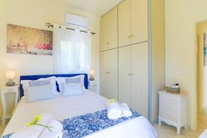 a bedroom with a blue and white bed with towels on it at Villa Seasunrise in Perama