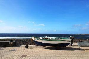 a boat is parked on the beach near the ocean at CASA MAR GINES , COMODIDAD Y CERCANIA A TU MANO. in La Santa