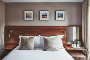 a bedroom with a white bed with three pictures on the wall at The Ranald Hotel in Oban