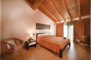 a bedroom with a bed and a chair in a room at La Casa del Nonno in Monzambano