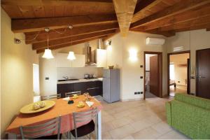eine Küche und ein Esszimmer mit einem Tisch und einem grünen Sofa in der Unterkunft La Casa del Nonno in Monzambano