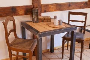 einen Holztisch mit 2 Stühlen, einem Tisch, einem Tisch und einem Tisch in der Unterkunft Doppelzimmer Anna Oberlausitzer Hof in Leutersdorf