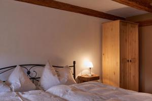 Schlafzimmer mit einem Bett mit weißer Bettwäsche und Kissen in der Unterkunft Doppelzimmer Anna Oberlausitzer Hof in Leutersdorf