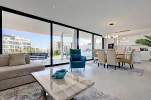 een woonkamer met een bank en een tafel bij 092 - Ultra Modern, Spacious Apartment With Private Garden & BBQ in Málaga