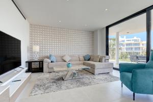 een woonkamer met een bank en een tafel bij 092 - Ultra Modern, Spacious Apartment With Private Garden & BBQ in Málaga