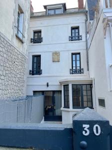 ein weißes Gebäude mit einer Nummer davor in der Unterkunft Villa Madeleine rénovée plage hyper centre in Trouville-sur-Mer