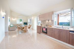 Una cocina con gabinetes de madera y una mesa con sillas. en Villa Plagia, en Gáios