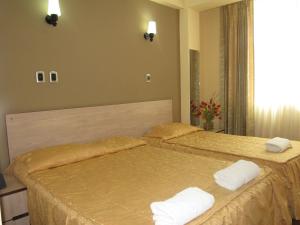 Dos camas en una habitación de hotel con toallas. en Hotel Torresur Tacna, en Tacna