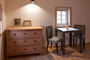 een slaapkamer met een dressoir en een tafel en stoelen bij Doppelzimmer Dora Oberlausitzer Hof in Leutersdorf