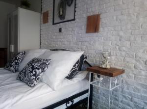 - une chambre avec un lit et un mur en briques dans l'établissement K 2, à Jastrzębia Góra