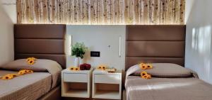 a bedroom with two beds with sunflowers on them at Villaggio Heliopolis in Manerba del Garda