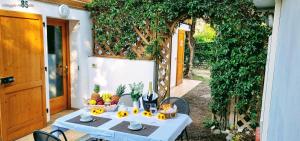a table with fruits and wine bottles on a patio at Villaggio Heliopolis in Manerba del Garda