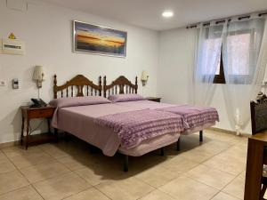 a bedroom with a bed with a purple comforter at Llar de Capitans in El Masnou