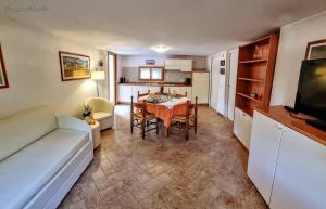 a living room with a table and a kitchen at Villaggio Heliopolis in Manerba del Garda