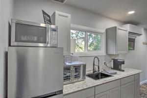 a kitchen with a stainless steel refrigerator with a microwave at Unique Container Studio with Deck and Fire Pit! in Buckley