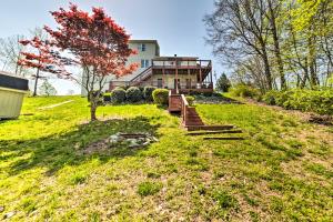 a house on a hill with a tree in the yard at Cadiz Abode with Decks, Fire Pit, and Lake Access in Cadiz
