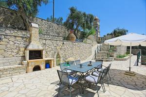a patio with a table and chairs and a fireplace at Villa Katerini in Gaios