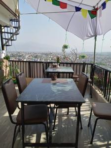 uma mesa e cadeiras numa varanda com um guarda-sol em Green Mandala Inn em Catmandu