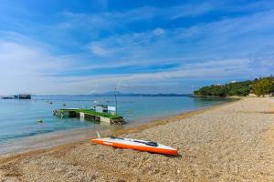 una barca arancione seduta sulla riva di una spiaggia di Villa Kiki a Agios Spyridon Corfu