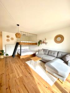 a living room with a gray couch and a wooden floor at Best Butler Family & Friends Fun Flat Netflix in Füssen