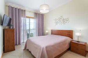 A bed or beds in a room at Ocean view Apartment with panoramic Terrace, 2 Swimming pools & Tennis court