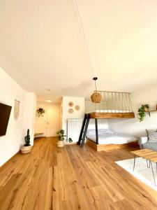 a living room with a loft bed and wooden floors at Best Butler Family & Friends Fun Flat Netflix in Füssen