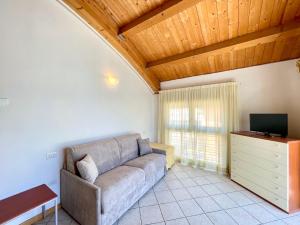 a living room with a couch and a television at Diani Beach - Carraro Immobiliare Jesolo - Family Apartments in Lido di Jesolo