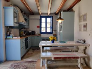 d'une cuisine avec des placards bleus et une table. dans l'établissement Marilia house, à Hydra