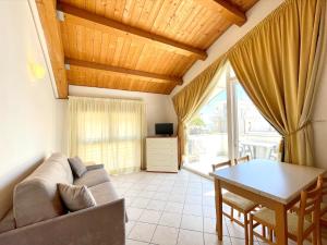 ein Wohnzimmer mit einem Sofa und einem Tisch in der Unterkunft Diani Beach - Carraro Immobiliare Jesolo - Family Apartments in Lido di Jesolo