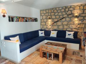 a living room with a blue couch and a table at Marilia house in Hydra