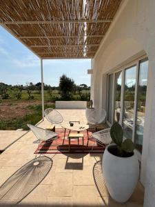 聖塔卡特林納迪納爾多的住宿－Villa Casa Bianca di Porto Selvaggio，天井配有桌椅和盆栽植物