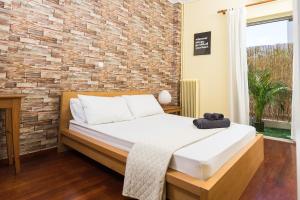 a bedroom with a bed and a brick wall at Malvina's Dream - Comfort and style-Central Aigio in Aigio