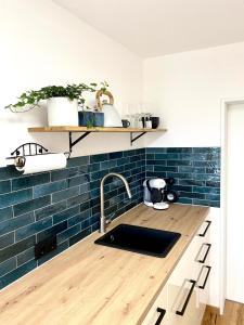 a kitchen with a sink and blue tiles at Best Butler Family & Friends Fun Flat Netflix in Füssen