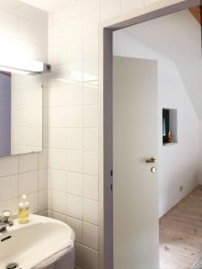 Baño blanco con lavabo y espejo en ENTZÜCKENDES GÄSTESTÖCKL am Linzer Pöstlingberg, en Linz