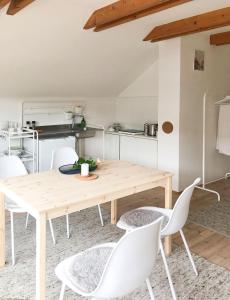 a dining room with a wooden table and white chairs at ENTZÜCKENDES GÄSTESTÖCKL am Linzer Pöstlingberg in Linz