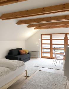 a bedroom with a bed and a couch and a table at ENTZÜCKENDES GÄSTESTÖCKL am Linzer Pöstlingberg in Linz