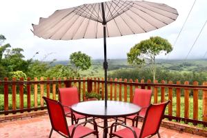a table and chairs with an umbrella on a balcony at El Portal De Don Luis in Guadalupe