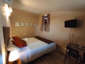 a bedroom with a bed with pillows and a television at All'Archetto del Terz'Ordine in Assisi